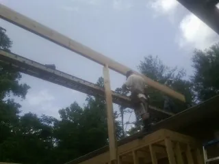 Carpenter setting a ridge beam over a new addition frame — Ice Dam Removal by Roofing Brothers in Moneta