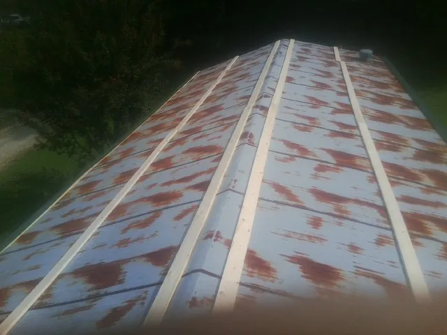Rusted metal roof panels with new wood purlins before replacement — Storm Damage Roof Repair in Moneta by Roofing Brothers