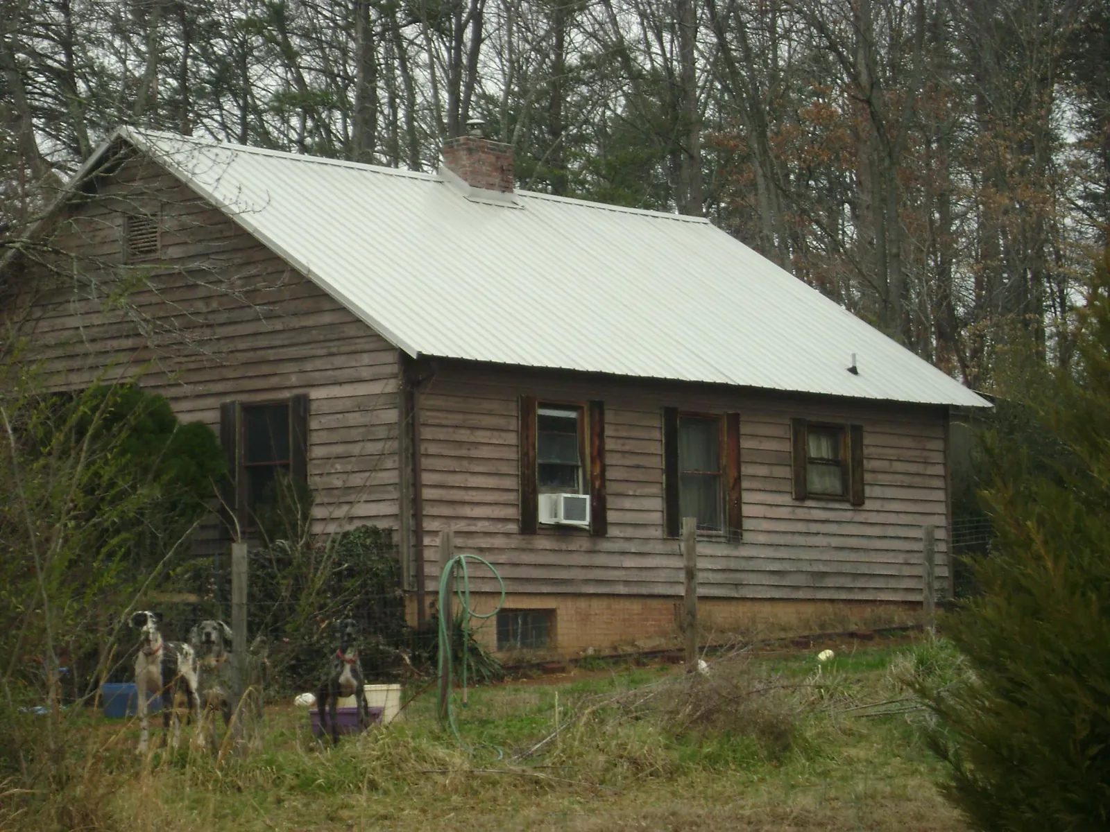 White metal roof on an old wood sided farmhouse, from a Metal Roof Installation job in Moneta